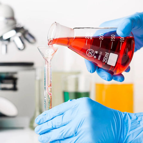 Pouring red liquid from 250ml Erlenmeyer flask with printed graduations into a small tube in a lab setting. 3 Piece Glass Erlenmeyer Flask Set 50ml 150ml 250ml with Stoppers and Cleaning Brush Borosilicate 3.3 Narrow Mouth Lab Conical Flasks with Printed Graduation for Precise Chemistry Experiments visible in background.