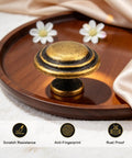 10 Pack Antique Brass Round Top Ring Cabinet Knobs, 35mm Diameter Zinc Alloy Handles, displayed on wooden tray with flowers