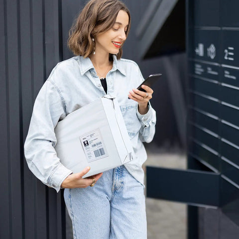 Person holding a package in 10x13 Inch Poly Mailers 200 Pack White For Clothing Shipping Envelopes Tear Resistant