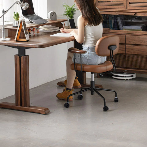 Woman sitting on office chair with 1.5 inch swivel furniture casters at wooden desk in modern room.