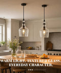 BNHHLZ Seeded Glass Pendant Light for Kitchen Island, Matte Black Teardrop Hanging Light Fixture, Adjustable Cord Modern Farmhouse Ceiling Lamp with Open Bottom above a kitchen island.