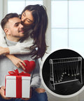 Couple with gift featuring 12 Ball Newtonian Pendulum Wave Desktop Decoration in white acrylic frame with stainless steel balls