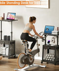 Height Adjustable Standing Desk On Wheels With Drawer And Storage beside exercise bike, showing laptop and storage