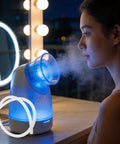Woman using a facial steamer next to a silicone steamer tube. Silicone Steamer Tube 39 Inch Heat Resistant Steam Hose For Home Sauna Conduit Replacement Flexible 0.4 Inch Inner Diameter High Temp Tubing For Steam Lines Durable Easy Setup visible in image.