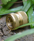 Side view of a Brass 4-Piece Quick Connect Garden Hose Fitting, heavy-duty adapter with grippy handle, on ground amid grass.