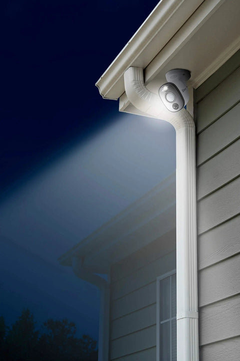 4K Ultra HD Outdoor Or Indoor Security Camera System With Sensor Spotlight mounted on house corner at night