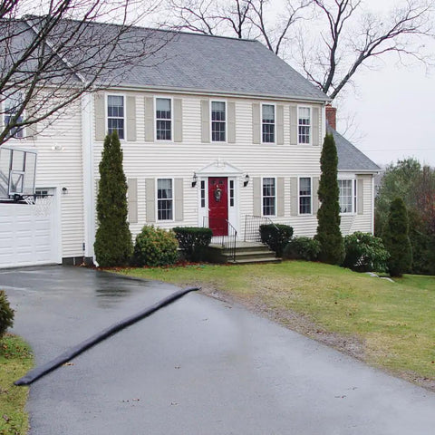 Grab And Go Flood Kit With Five 10ft Flood Barriers in front of a house, showing water-activated barriers on a driveway.