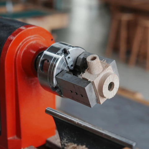 NCK Series Quick Change Woodturning Lathe Jaws for Pipe and Spoon Making attached to lathe with a wood piece