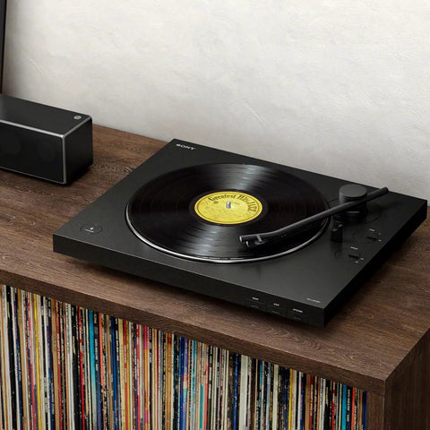Sony PS-LX310BT Belt Drive Turntable Fully Automatic Wireless Vinyl Record Player on a wooden shelf with records nearby.