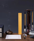 Yellow Portable Poster Tube Storage With Spacious Interior on a desk with art supplies, brushes, and books