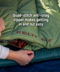 Person demonstrating zipper on Cosmic 20 Down Mummy Sleeping Bag With 550 Fill Power Down, Recycled Fabrics And PFAS Free DWR