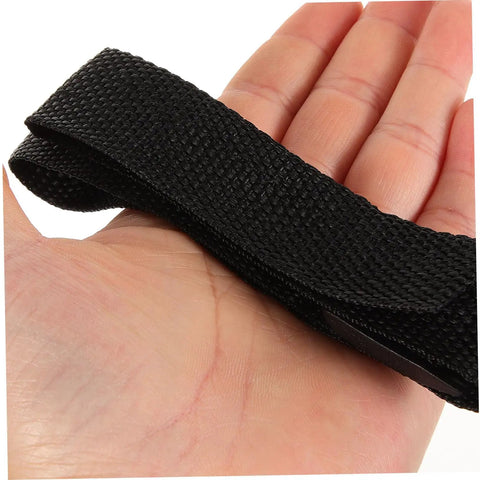 Hand holding a black nylon strap from the Adjustable Lawn Aerator Shoes Straps 8 Pack for heavy duty spiked sandals