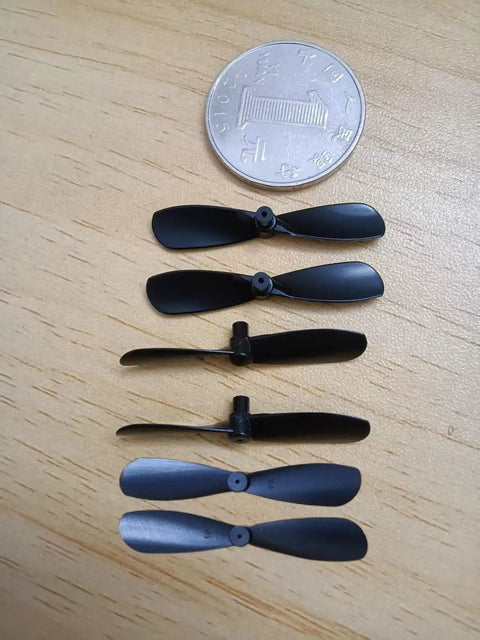 Pro Grade 20-Pack 1.38 Inch Mini Propellers for RC Aircraft shown with a coin for scale, black durable nylon blades.