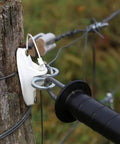 Close-up of 10 Piece T Post Gate Hook Set For Electric Fence High Tensile Ranch Farm And Property Heavy Duty Eyelet Insulator on wood post