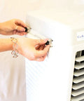 Hands adjusting the controls of a Heavy Duty Portable Evaporative Swamp Cooler With 3000 CFM Blower And Ten Gallon Ice Ready Tank.