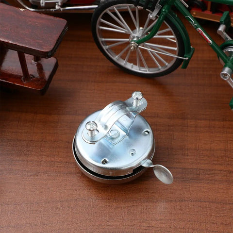 Loud As Heck Clear Safety Bell For Electric Scooters And City Commuter Bikes Fits 0.86 To 1.18 Inch Handlebars Easy Thumb Trigger Install Audible Ring That Cuts Through Traffic Ideal For Bikes Cruisers And Trikes, silver metal bell on wood table