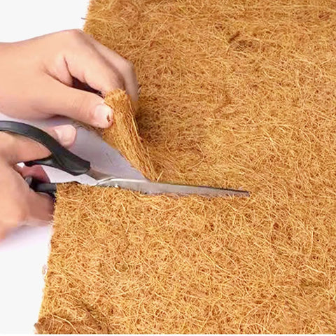 Person cutting Natural Coconut Coir Liner Roll 12x80 Inch Thick Coco Fiber Sheets for Planters with scissors, showing texture.
