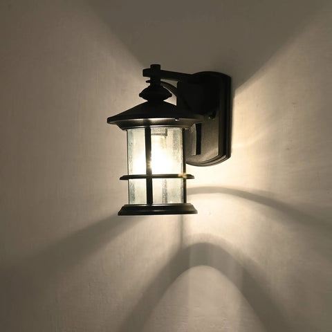 Illuminated massive 12.5 inch outdoor wall light fixture with textured black finish and clear seeded glass shade, E26 base.