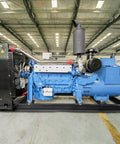 Heavy Duty Industrial Generator Set Featuring No Sweat Standby Power Delivery For Commercial Sites And Emergency Backup Power Needs That Will Crush The Daily Grind At Any Hustle. Side view of blue generator engine in warehouse.