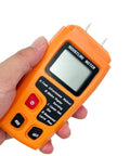 Hand holding Pro Grade Wood Moisture Meter Digital Humidity Tester For Timber With Four Modes A And B Teak Walnut Afrormosia White Poplar Large LCD Display Orange Case Delivers 0 To 99.9 Percent Moisture Reading With Less Than 0.5 Percent Accuracy