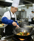 Chef using Tough As Nails Heat Resistant Welding Sleeves Fireproof Arm Protectors Zero Sweat Breathable Wrap Pro Grade Armor For Scorching Shop Grind And Heavy Auto Repair Blue while cooking in a restaurant kitchen.