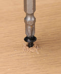 Close-up of Heavy Duty 8 By 3 8 Truss Head Wood Screws With Phillips Recess being driven into wood surface.