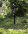 Ergonomic Garden Fork With Four Prongs, 122 Cm Long, Boron Steel, Grey And Black, Heavy Duty Digging Tool standing in grass