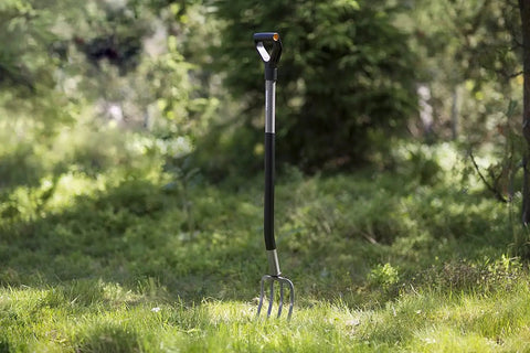 Ergonomic Garden Fork With Four Prongs, 122 Cm Long, Boron Steel, Grey And Black, Heavy Duty Digging Tool standing in grass