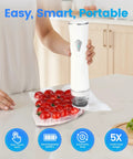 Person using Visible Tank Handheld Food Vacuum Sealer With One Touch Strong Suction, sealing bag of tomatoes, white device on kitchen counter.