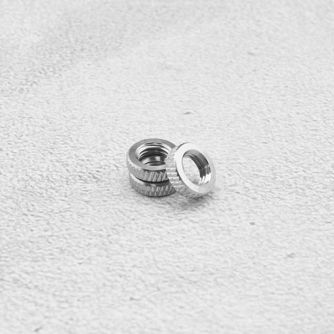 Two metal lock rings from Presta Valve Core Lock Ring Nuts Set 10 Pack Durable Metal Lock Rings For Presta Valves And Bicycle Inner Tubes Rust Resistant 5mm Inner Diameter 10mm Outer Fits Air Pumps And Compressors on textured surface