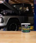 Masters Heavy-Duty No. 3 Wheel Bearing Grease, 16 oz can on workbench in garage with raised truck in background