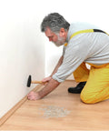 Man installing baseboard with double headed skirting nails with six sleeve tools for invisible seamless baseboard installation and trim.
