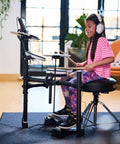 Child playing Dope Entry Level Electronic Drum Kit With Expressive Playability, Noise-Reducing Pads in a cozy room setting.