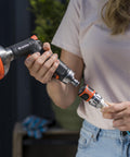 Woman connecting premium metal quick connect hose fittings set for five eighths or half inch hoses, no kink, watertight kit