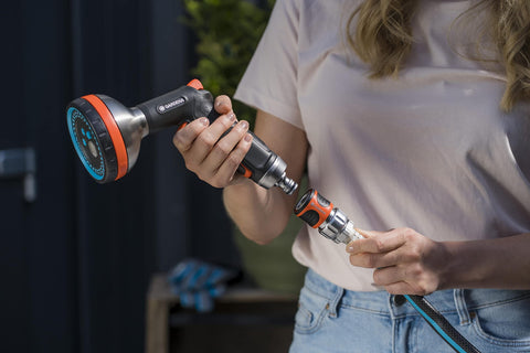 Woman connecting premium metal quick connect hose fittings set for five eighths or half inch hoses, no kink, watertight kit