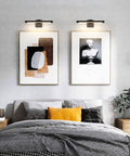 Bedroom with Sleek 16.53 Inch LED Picture Light For Paintings, Black Wall Lamp illuminating two framed artworks above bed.