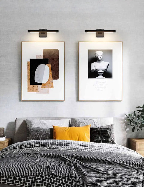 Bedroom with Sleek 16.53 Inch LED Picture Light For Paintings, Black Wall Lamp illuminating two framed artworks above bed.