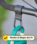 Stroller Strap 2 Pack With Hook and Loop Attachments clipped on handlebar holding a green bottle for hands-free travel