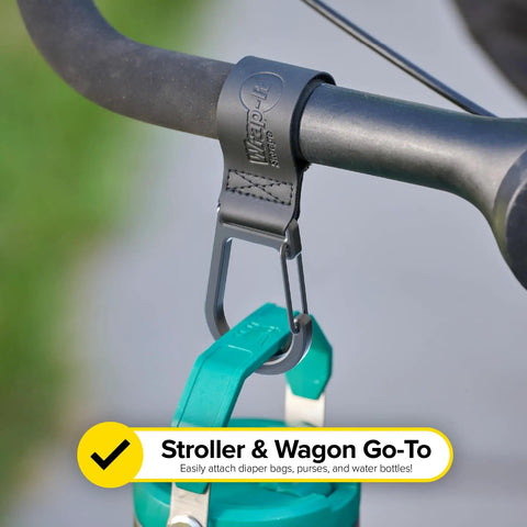 Stroller Strap 2 Pack With Hook and Loop Attachments clipped on handlebar holding a green bottle for hands-free travel
