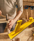 Man using heavy-duty push handle with visible yellow push block for woodworking tables and router tables, safe precision cuts tool.