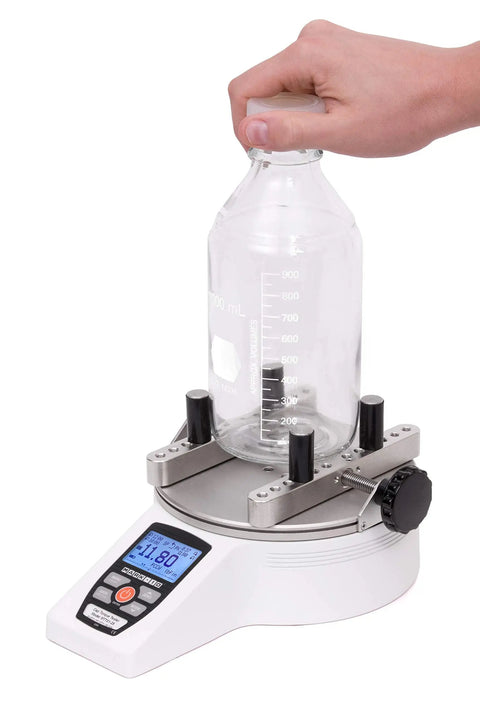 TT01 Cap Torque Tester With 100 LbFin Capacity, Adjustable Posts And Jaws, Automatic Data Output And Zeroing, First And Second Peak Detection For Slip And Breakaway Torques In Tamper Evident Closures. Bottle cap torque test on 1 L plastic bottle.