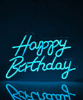 Blue Happy Birthday Neon Sign For Wall Decor With Dimmable USB Switch Reusable Neon Light For Birthday Parties Lit Vibes 17 By 12 Inch Silicone LED Strip Sign On Clear Acrylic Board glowing in dark room.