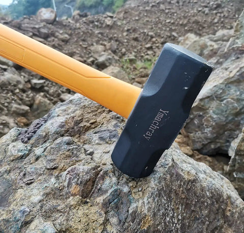 10 Pound Sledge Hammer for Heavy Duty Demolition with 35 Inch Fiberglass Handle resting on a rock, showcasing textured grip.