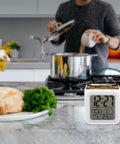 Vintage Tractor Photo Farm Alarm Clock With LED Display on kitchen counter with bread and herbs, showing time and temperature.