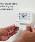 Smart WiFi Thermostat With Conventional And Heat Pump Compatibility, X2S Gray, being installed on a white wall