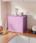 Slick 1.1 Cu Ft Compact Countertop Upright Freezer Featuring Smooth Temperature Dial And Handy Removable Shelf In Vibrant Pink on a kitchen countertop.