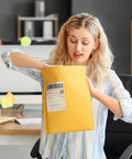 Person using Yellow Kraft Bubble Mailers 25 Pack Self Sealing Padded Envelopes 10.5 By 16 Inch Outer Size With Usable 10.5 By 15 Inch