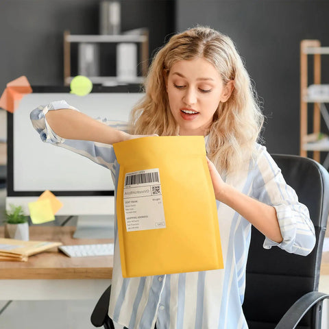 Person using Yellow Kraft Bubble Mailers 25 Pack Self Sealing Padded Envelopes 10.5 By 16 Inch Outer Size With Usable 10.5 By 15 Inch