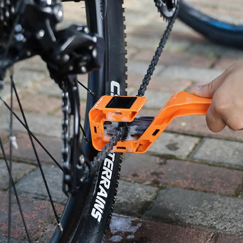 Person using the Two Pack Upgraded 4 Sided Bike Chain Washer With Fully Enclosed Chain Cleaning Brushes Extended Ergonomic Handle Durable Bicycle Chain Cleaner Tool For Mountain Road Bikes on a bicycle chain.