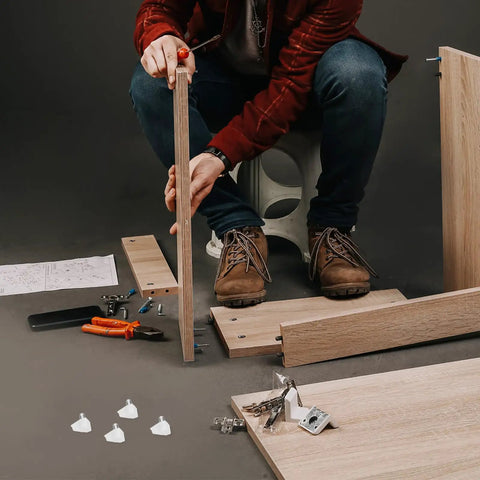 Person assembling furniture using 100 Pack White Plastic And Stainless Steel Shelf Pegs For Wine Cabinets Bookcases And Furniture